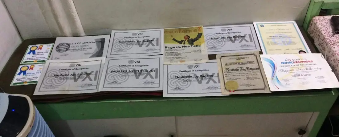 A table covered with VXI and Startek recognition certificates