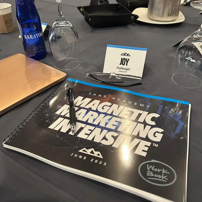 SaaS Academy workbook and a name card reading Joy